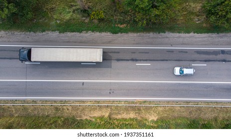 Aerial. Traffic by the rural highway. Sedan car and truck on the motorway. Top view from drone.