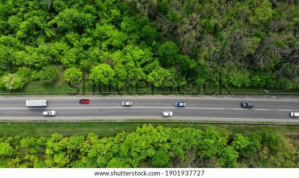 Aerial. Traffic on the intercity highway\
between the natural parkland. Top view from\
drone.