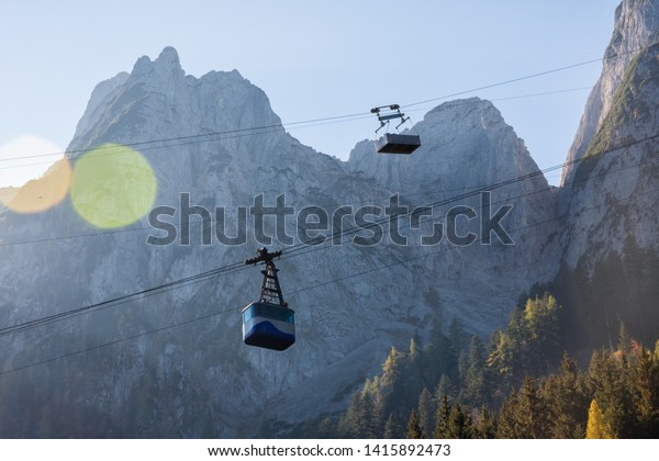 Aerial tramway (gondola lift)\
and rocky peaks in the alp mountains. Beautiful natural\
scenery.