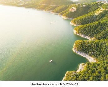 Aerial trees and cliff rock wall, bluffs at Lake Travis, Austin, Texas, USA. Luxury vacation homes and house on coastline. Looking down houses in community, ocean crystal background