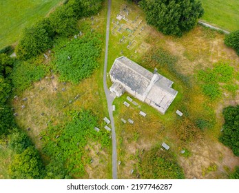 Aerial View Of 12th Century Chapel. St Mary's Church Stainburn Built English Gothic Architecture And Set Within British Countryside