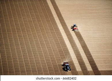 An aerial view of 2 tractors planting potatoes in the fertile farm fields of Idaho, during the spring. - Shutterstock ID 66682402