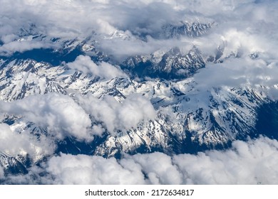 Aerial view at 38,000 feet of snow covered mountain tops around Birch County, Alberta, Canada at 55 41.1542N 118 32.675W - Powered by Shutterstock