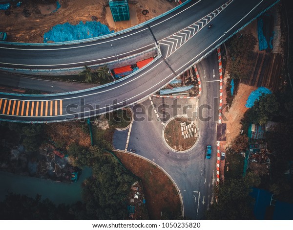 Aerial\
View Above of Busy Highway Intersection Road Junctions at morning.\
The image contain soft focus, grain and\
noise.