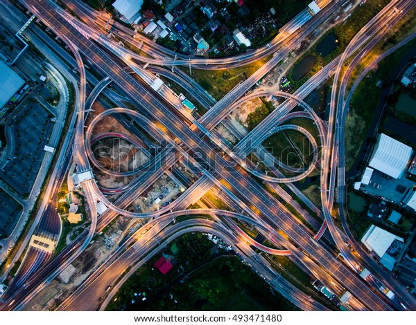 Aerial View Above of Busy Highway Road Junctions\
at Night. The Intersecting Freeway Road Overpass The Eastern Outer\
Ring Road of Bangkok.