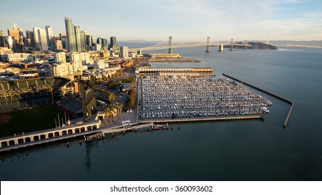 Aerial view from above McCovey Cove in the San Francisco Bay shows the South Beach Marina, the SOMA district, the San Francisco-Oakland Bay Bridge, and the rising skyline of Rincon Hill