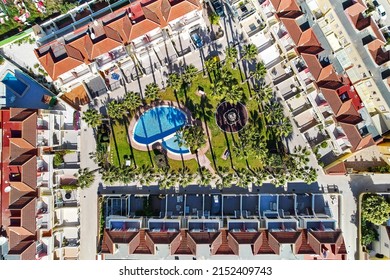 Aerial View From Above Modern Urbanization Rooftops With Well-groomed Inner Yard Garden, Palm Trees And Swimming Pool, No People. Summer Vacation, Rental Apartment, Travel Concept. Costa Blanca, Spain