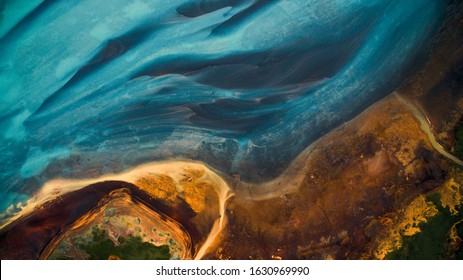 Aerial view from above on a green and blue glacier river stream in 
South Iceland. Beautiful patterns, textures and structures. Melting glacier,  Global warming and climate change concept