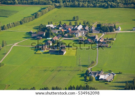 Similar – A tractor turns mown hay in a field in a small community