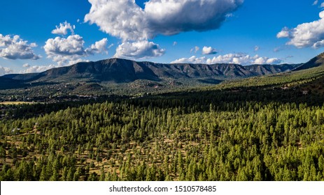 Aerial View Above The Pine Trail Head Near Pine And Arches State Park, Arizona On A Beautiful Cloudy Day With Green Pine Trees, Blue Sky, Hills, Ridges Along The Mogollon Rim