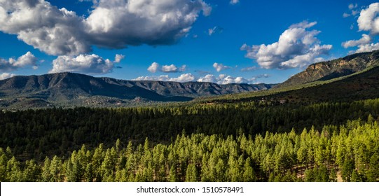 Aerial View Above The Pine Trail Head Near Pine And Arches State Park, Arizona On A Beautiful Cloudy Day With Green Pine Trees, Blue Sky, Hills, Ridges Along The Mogollon Rim