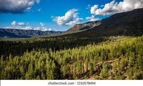 Aerial View Above The Pine Trail Head Near Pine And Arches State Park, Arizona On A Beautiful Cloudy Day With Green Pine Trees, Blue Sky, Hills, Ridges Along The Mogollon Rim