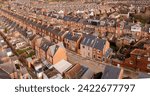 An aerial view above the rooftops of run down back to back terraced houses on a large residential estate in the North of England