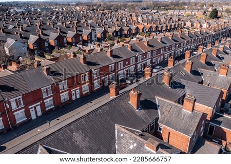 An aerial view above the rooftops of run down back to back terraced houses in the North of England