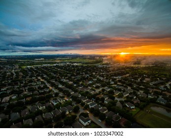 Aerial View Above Suburb Neighborhood Real Estate Market New Home Ownership And City Living In Suburbia Community North Of Austin , Texas During Amazing Sunset With Spots Of Ominous Fog On The Horizon