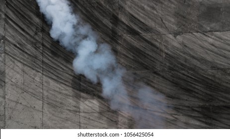 Aerial view abstract background with tire marks and smoke on race track.