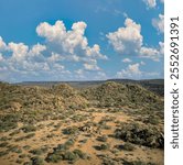 aerial view african landscape, mountain range and hills, savannah plain with acacia trees and bush , sunny afternoon