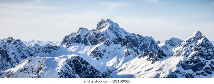 Aerial View From Airplane Of Blue Snow Covered Canadian Mountain Landscape In Winter. Bright Sunny Blue Sky. Tantalus Range Near Squamish, North Of Vancouver, BC, Canada. Nature Background