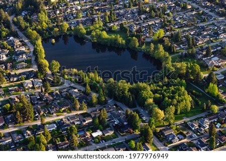 Aerial View from an Airplane of Residential Homes near a pond in Coquitlam, Greater Vancouver, British Columbia, Canada. Como Lake Park