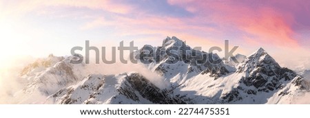 Aerial View from Airplane of Snow Covered Canadian Mountain Landscape in Winter. Colorful Pink Sky Art Render. Near Squamish, North of Vancouver, British Columbia, Canada.