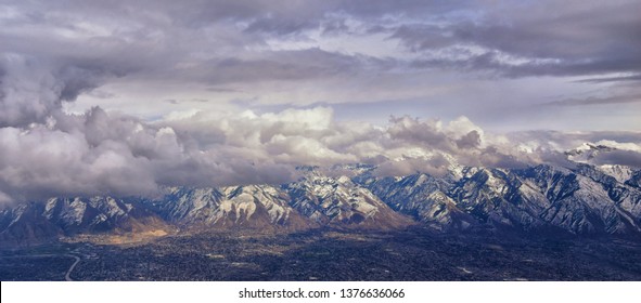 Aerial View From Airplane Of The Wasatch Front Rocky Mountain Range With Snow Capped Peaks In Winter Including Urban Cities Of Provo, Farmington Bountiful, Orem And Salt Lake City. Utah. United States