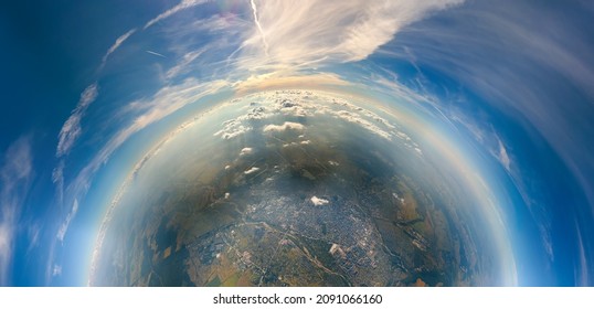 Vista aérea desde la ventana del avión a gran altitud de la pequeña ciudad lejana del planeta cubierta de capa de esmog niebla delgada y nubes distantes por la noche