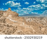 Aerial view of Alhama castle with large square keep restored using concrete and Iberian settlement ruins in Southern Spain Murcia province.