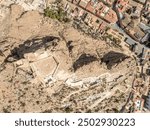 Aerial view of Alhama castle with large square keep restored using concrete and Iberian settlement ruins in Southern Spain Murcia province.