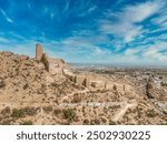 Aerial view of Alhama castle with large square keep restored using concrete and Iberian settlement ruins in Southern Spain Murcia province.