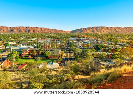 Aerial view of Alice Springs skyline in Australia from Anzac Hill Memorial lookout with main buildings of Alice Springs city downtown. Red Centre desert with Macdonnell ranges of Northern Territory.