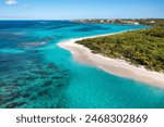 Aerial view along the waters, coral reef, palm trees and shoreline of Shoal Bay Beach on the island of Anguilla..