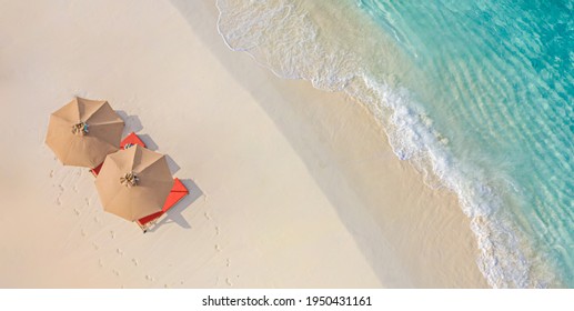 Aerial view amazing beach and umbrellas   lounge chairs beds close to turquoise sea  Top view summer beach landscape  idyllic inspirational couple vacation  romantic holiday  Freedom travel