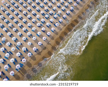Aerial view of an amazing empty sand beach with straw beach umbrellas and turquoise clear water. - Shutterstock ID 2315219719