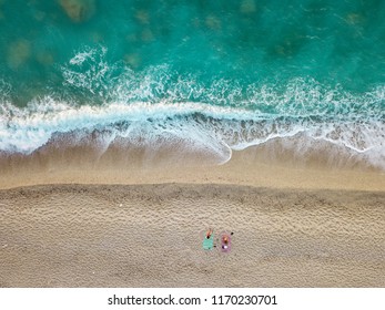 Aerial view of the amazing idyllic beach with two lonely people near waved sea. - Shutterstock ID 1170230701