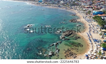 Aerial view of an amazing sand beach with turquoise warm waters packed with locals and tourists in the heart of Salvador, Bahia, Brazil