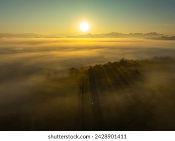 Aerial view amazing the sea of mist at beautiful sunrise.

slow floating fog blowing cover on the top of mountain look like as a sea of mist. 

white cloud in blue sky over the perfect forest. - Powered by Shutterstock