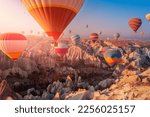 Aerial view amazing sunrise landscape in Cappadocia with colorful hot air balloon fly in sky over deep canyons, valleys. Concept banner travel Turkey.
