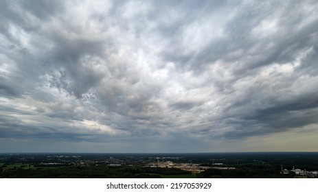 Aerial view amazing sunset over of the suburbs with the city under dramatic rain cloud. Global warming effect black thunderstorm dramatic rain clouds, dramatic sky, shot by a drone. High quality photo - Shutterstock ID 2197053929