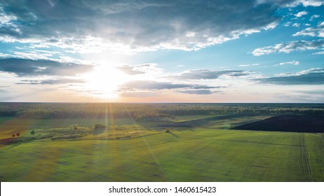 Aerial view of amazing sunset sky with last sunbeams illuminated green meadows; beautiful cloudscape with horizon line sky gradient; rural natural scene on a summer evening; steppes and open spaces - Powered by Shutterstock