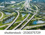 Aerial view of American freeway intersection with fast driving cars and trucks in Miami, Florida. USA city transportation infrastructure