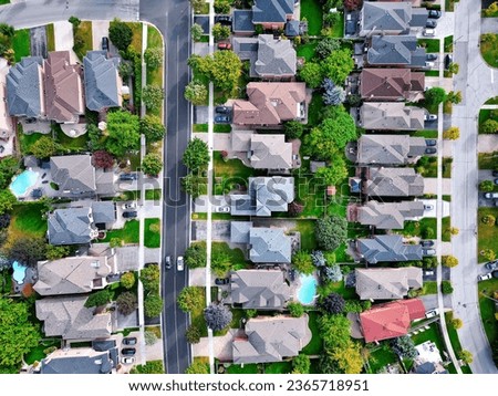 Aerial view of American suburb neighbourhood detached single homes and street surrounding by green trees in Richmond Hill, Ontario, Canada.  Established real estate community background.
