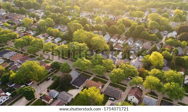 Aerial view of american suburb at summertime. 
Establishing shot of american neighborhood. Real estate,
residential houses. Drone shot, from
above