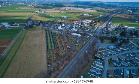 Aerial View Of An Amish Mud Sale With Lots Of Buggies And Farm Equipment On A Winter Day