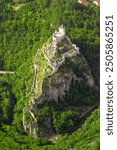 Aerial view of the ancient fortress in Uzice, Serbia, perched on a hilltop with scenic forest and mountain backdrop