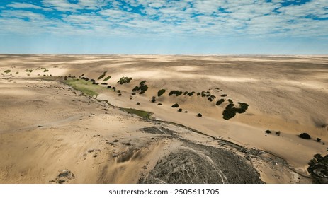 Aerial view of Angola's wild landscape showcasing vast deserts and sparse vegetation under a blue sky - Powered by Shutterstock