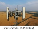 Aerial view of antennas on a self support telecom tower in rural scenic view. Drone view of a telecom tower top