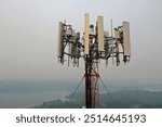 Aerial view of antennas on top of a telecom cell tower. A drone closeup view of antennas on a guyed tower.