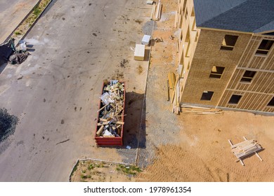 Aerial view of apartment framing of a new house under stacker wooden boards the trash dumpsters construction - Powered by Shutterstock