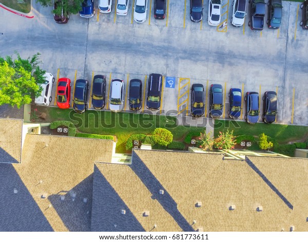 Aerial view of apartment garage with covered
parking lots, cars and green trees at multi-floor buildings complex
in Humble, Texas, US early morning. Urban infrastructure and
transportation concept.