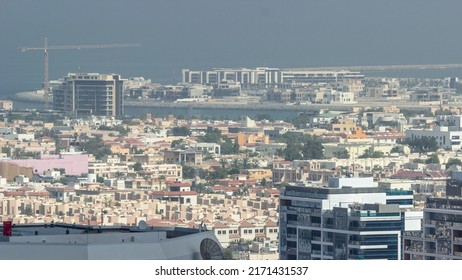 Aerial View Of Apartment Houses And Villas In Dubai City Timelapse From Skyscraper In Financial District, United Arab Emirates. Island In The Sea And Building Under Construction